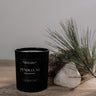 Black candle labeled 'Pendulum' on a wooden surface with a natural background