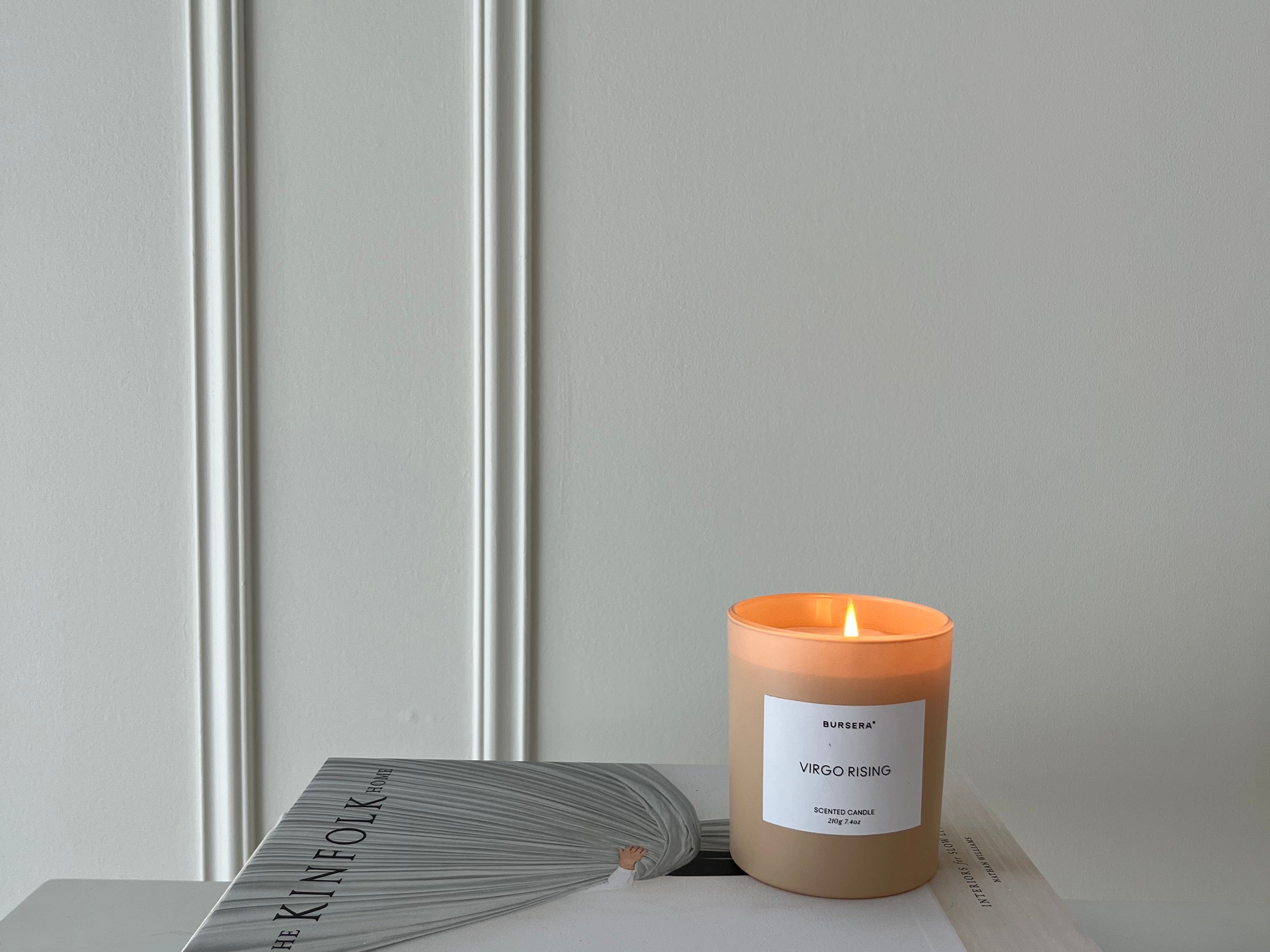 Candle burning on a stack of books with a neutral background