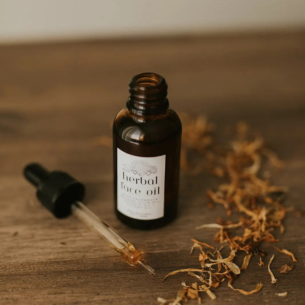 Bottle of herbal face oil with dropper on a wooden surface