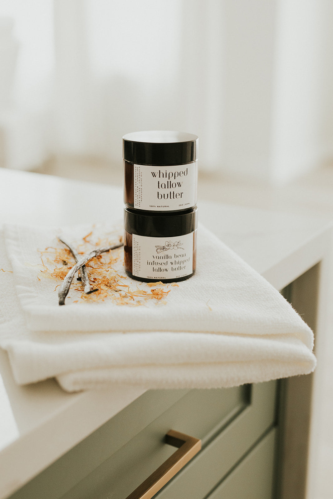 Two jars of whipped butter on a white surface with a blurred background