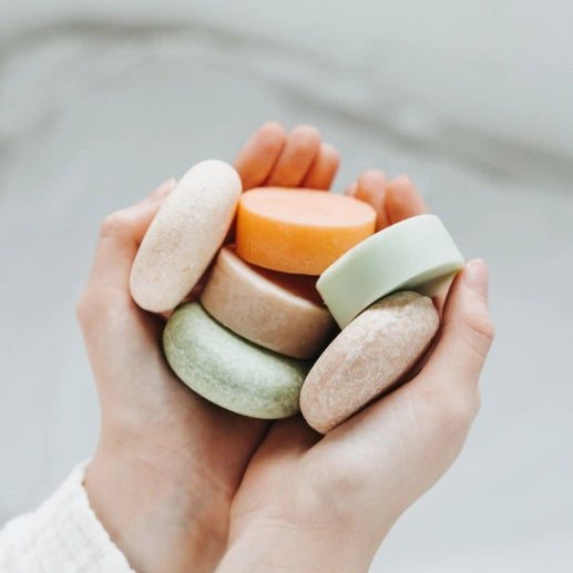 Hands holding a stack of colorful wooden rings against a neutral background