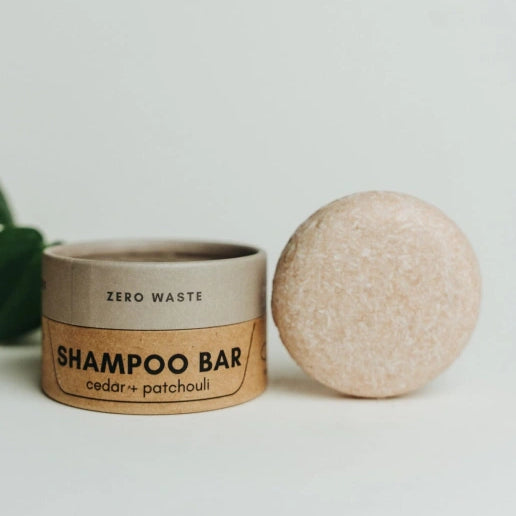 Shampoo bar and container with 'Zero Waste' label on a light background