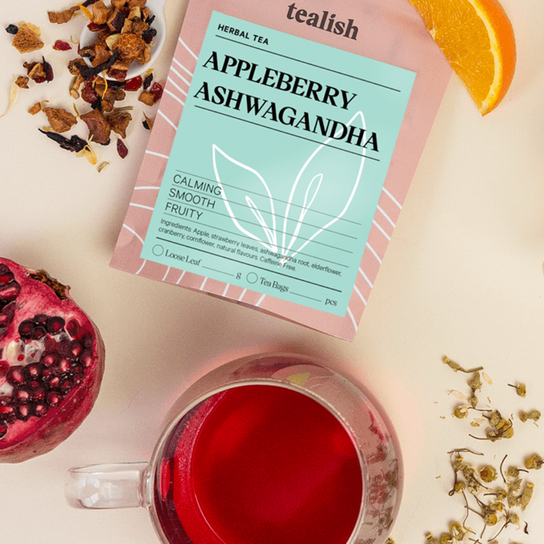 Tea package labeled 'Appleberry Ashwagandha' with a cup of tea, pomegranate, and orange on a light background.