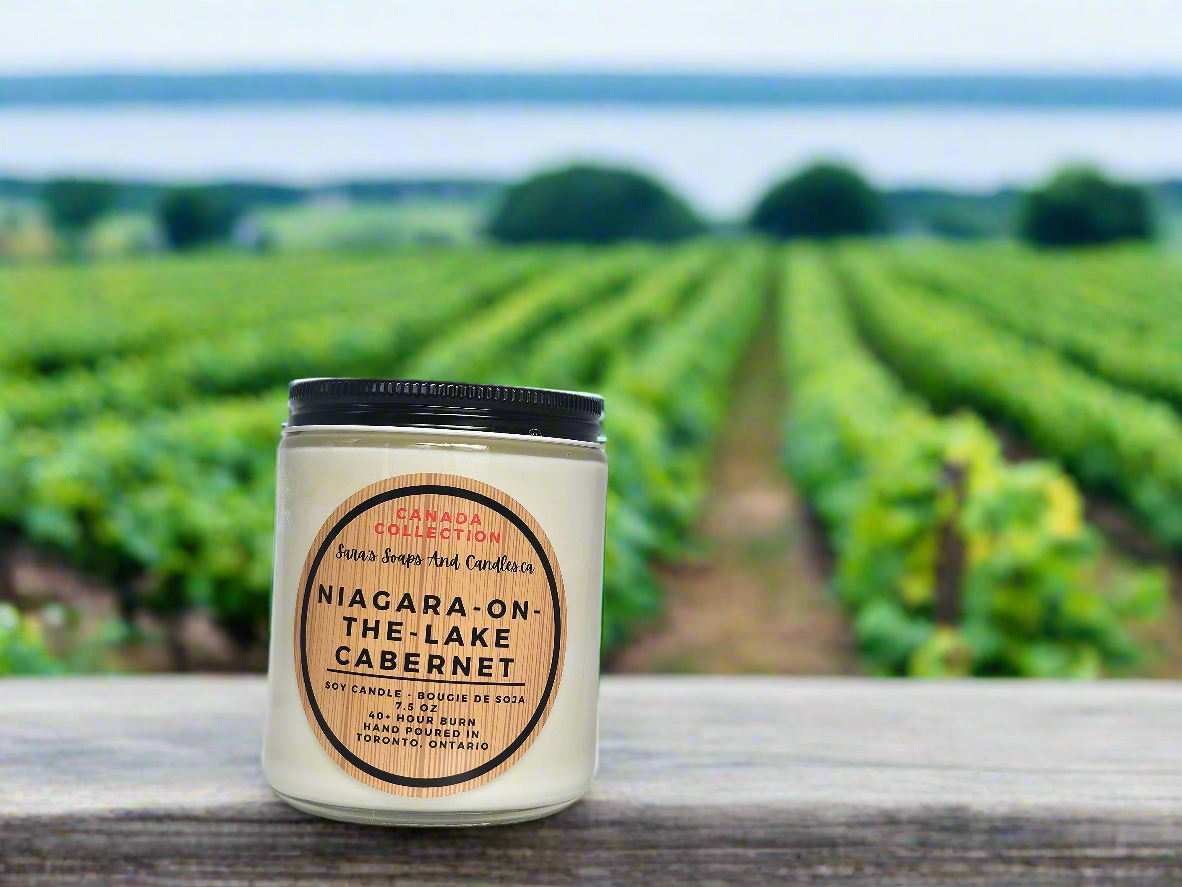 Candle labeled 'Niagara-on-the-Lake Cabernet' in front of vineyard