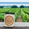 Candle labeled 'Niagara-on-the-Lake Cabernet' in front of vineyard