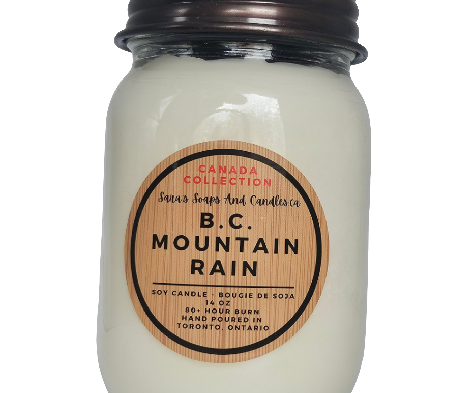 Jar candle labeled 'B.C. Mountain Rain' with a wooden label on a white background