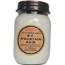 Jar candle labeled 'B.C. Mountain Rain' with a wooden label on a white background