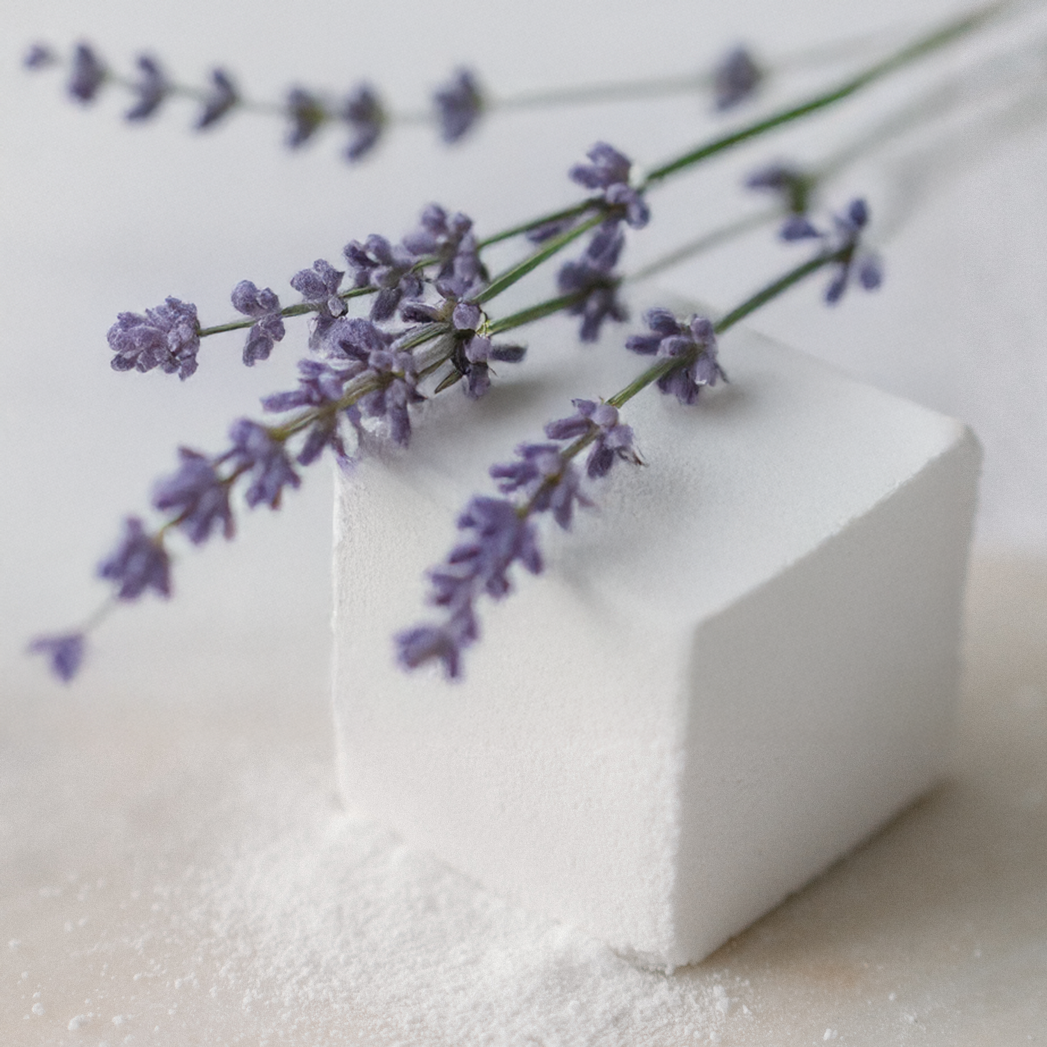 Lavender flowers on a block of white soap with a blurred background