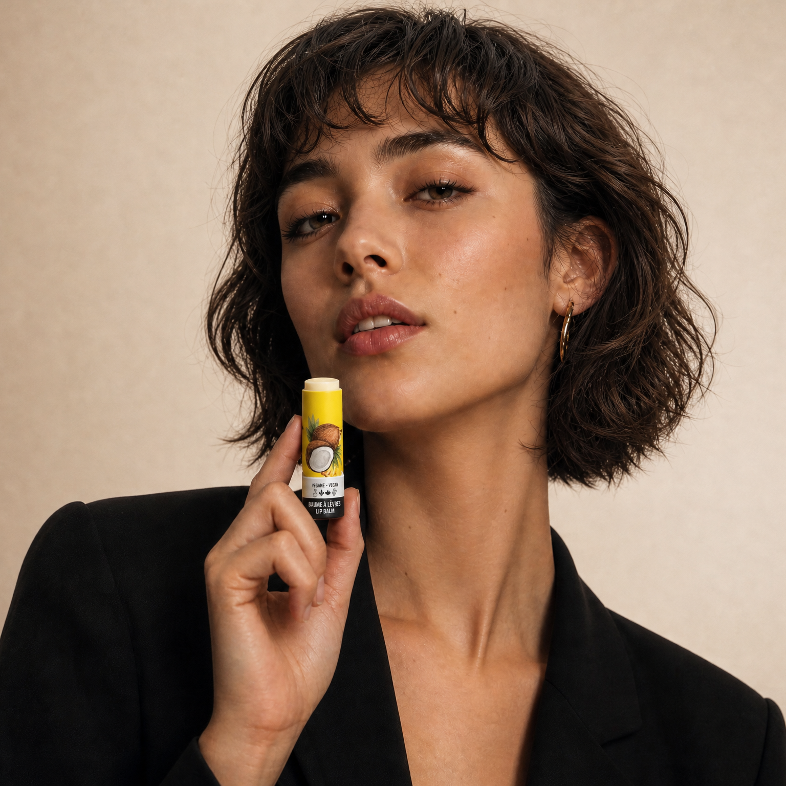 Woman holding a product against a beige background