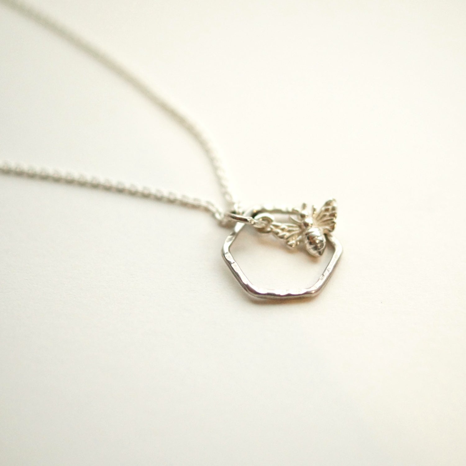 Silver necklace with a hexagonal pendant on a white background