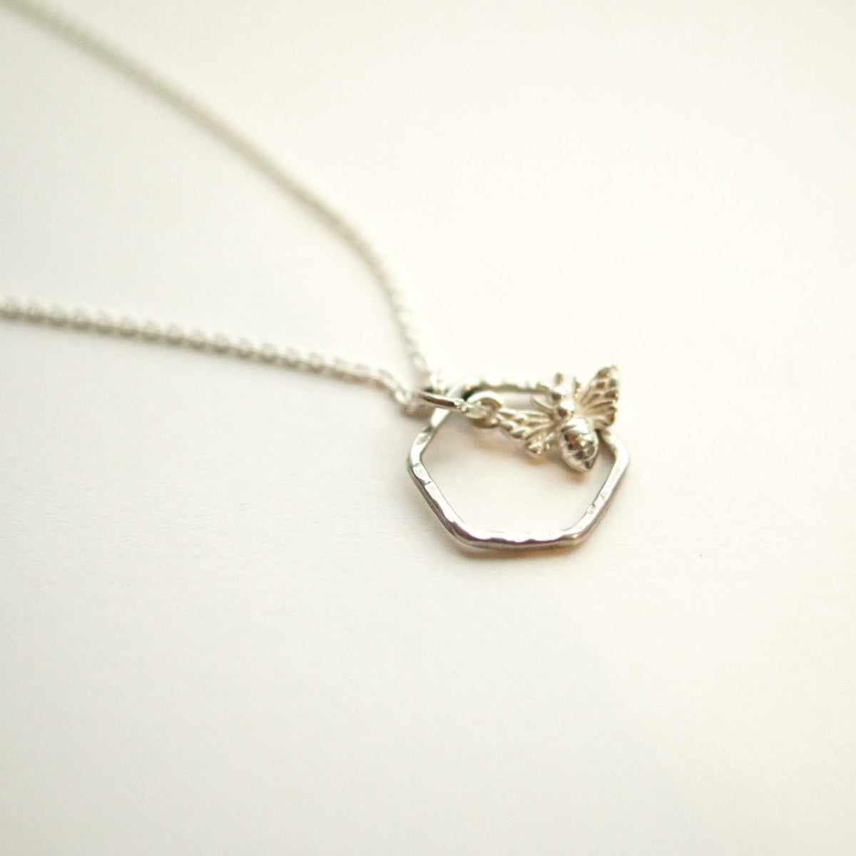 Silver necklace with a hexagonal pendant on a white background