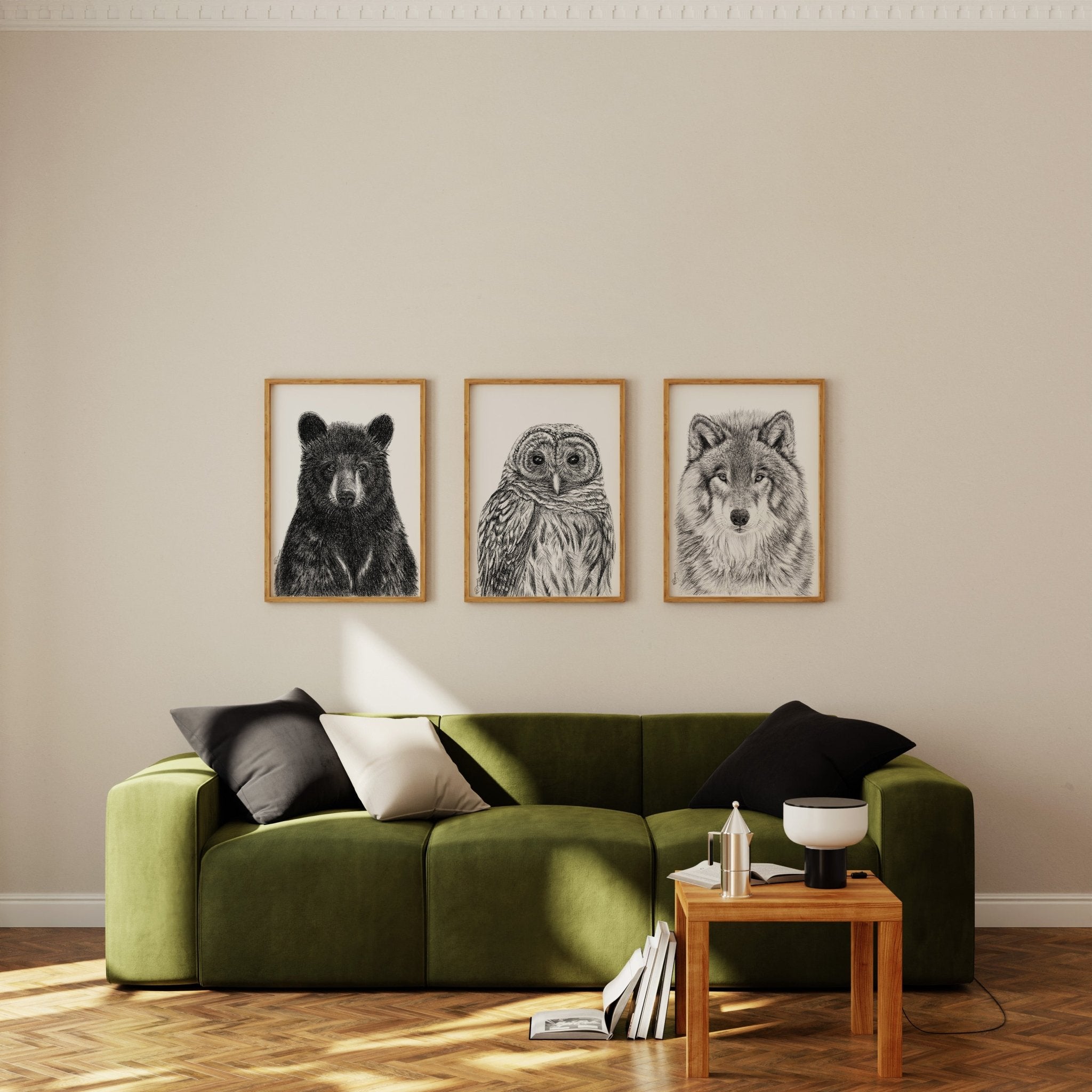 Green sofa in a living room with wall art of a bear, owl, and wolf.