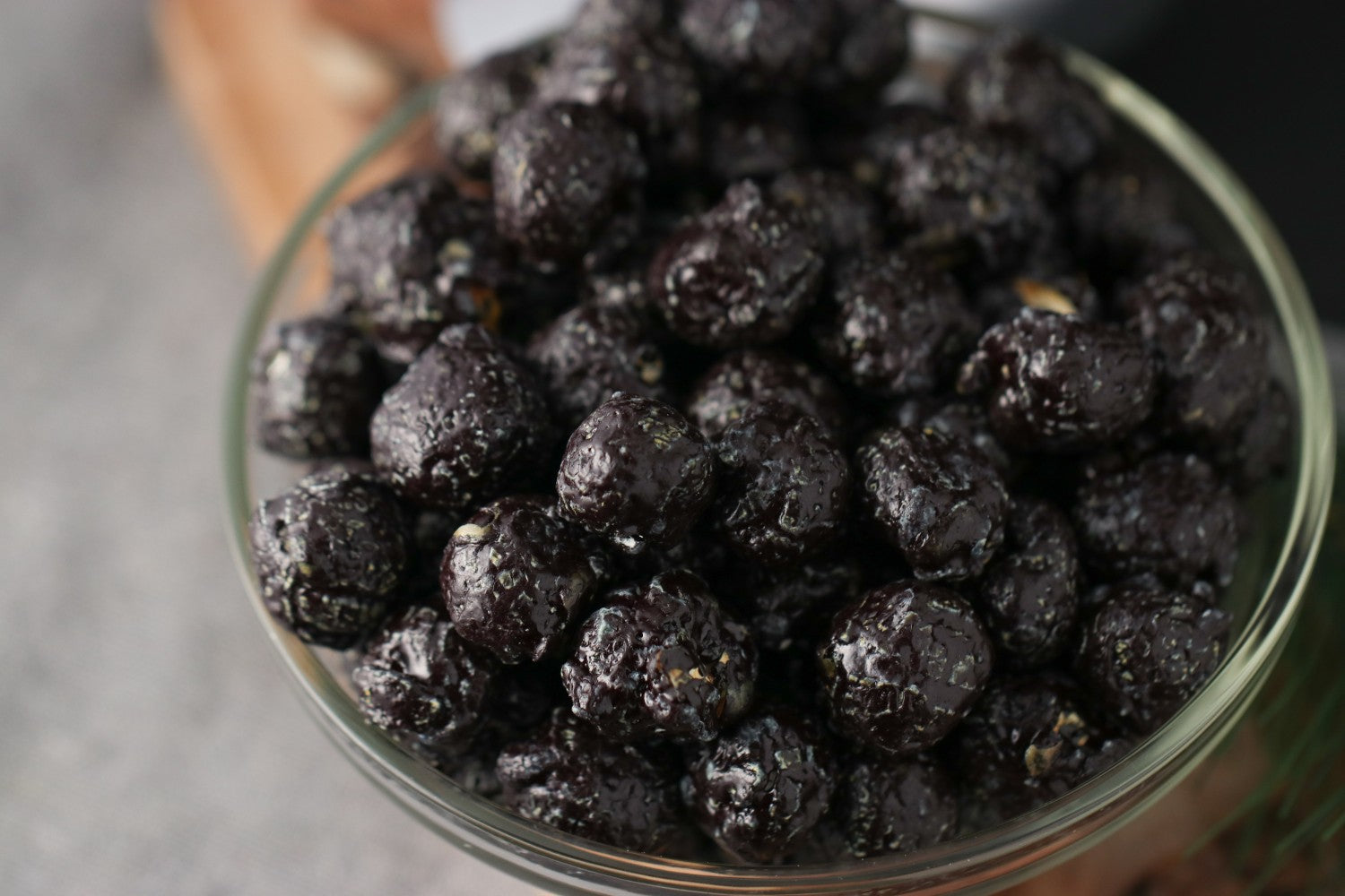 Bowl of candied black cherry popcorn on a wooden surface from Toronto Popcorn company