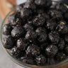 Bowl of candied black cherry popcorn on a wooden surface from Toronto Popcorn company