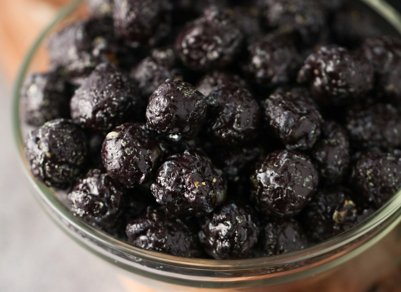 close view of a Bowl of candied black cherry popcorn on a wooden surface from Toronto Popcorn company