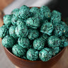 Bowl of blue raspberry candied popcorn on a wooden surface from Toronto Popcorn company