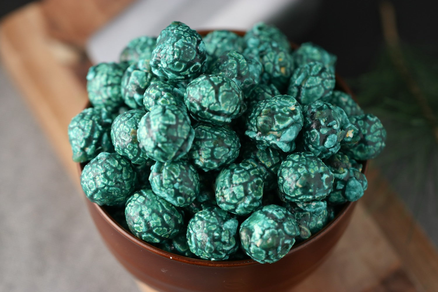 Bowl of blue raspberry candied popcorn on a wooden surface from Toronto Popcorn company