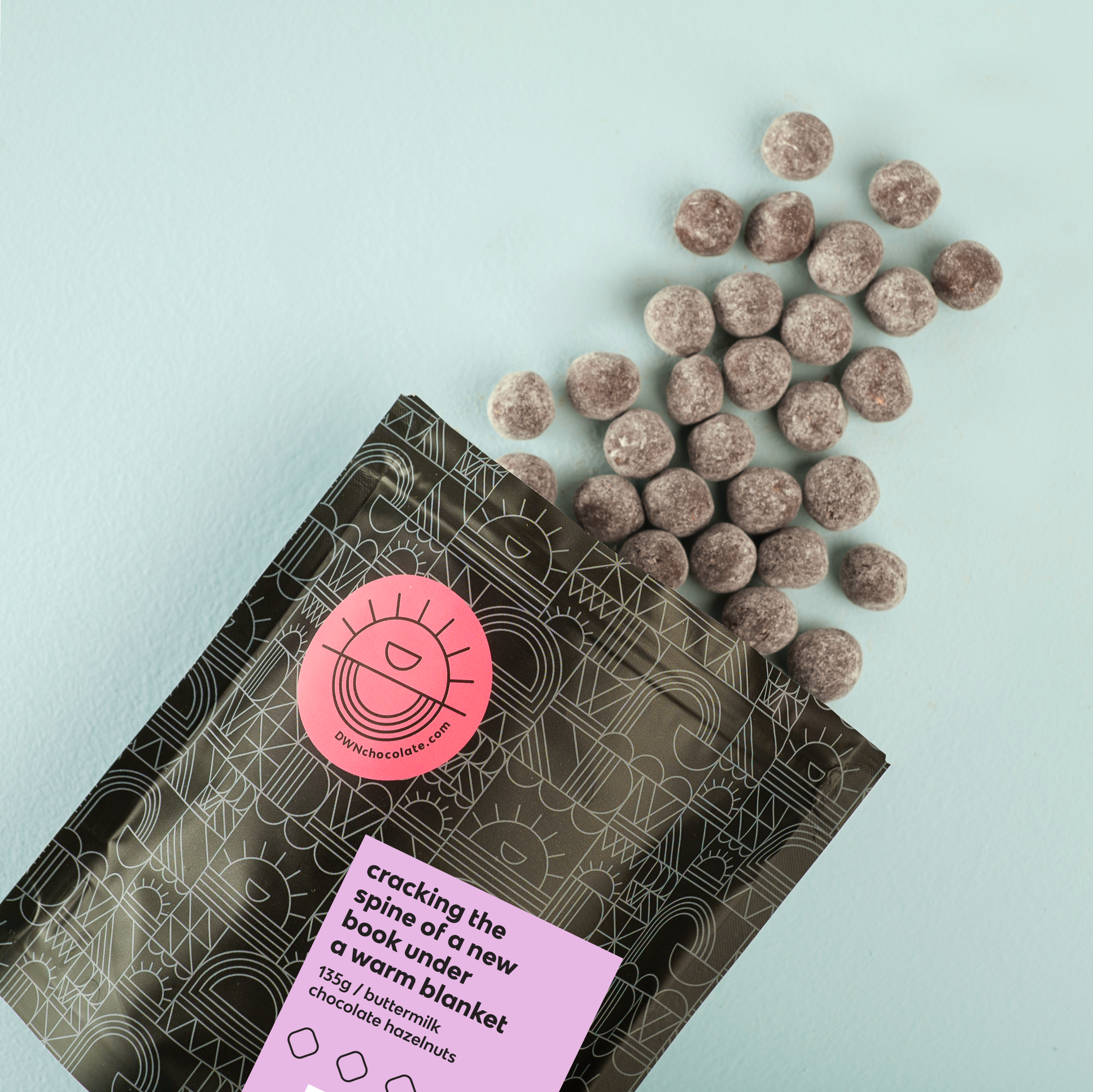 Packaged product with a pink label on a light blue background DWN Chocolate buttermilk hazelnut thumble