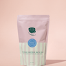 Bath soap package with a pink top and green label on a pink background