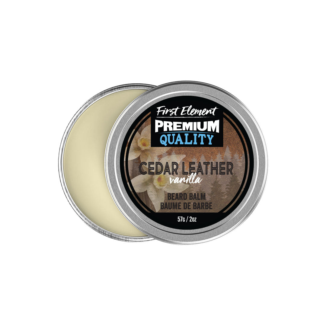 An open round metal tin of First Element Premium Quality Beard Balm in Cedar Leather vanilla scent, showing the pale cream balm inside next to the lid label.