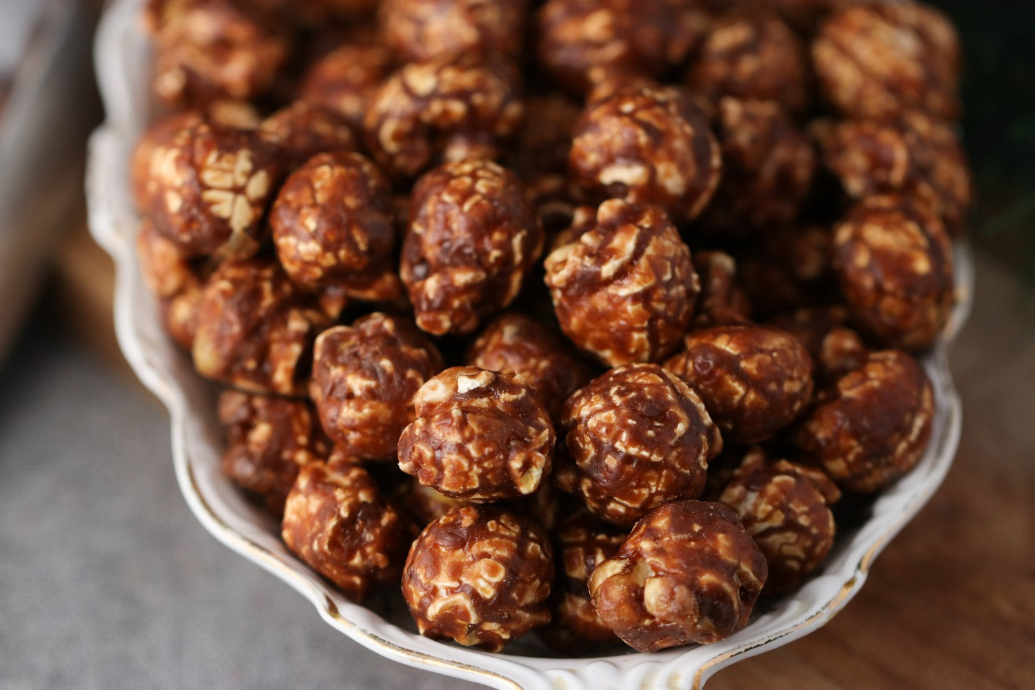Bowl of chocolate peanut candied popcorn on a wooden surface from Toronto Popcorn company
