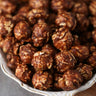 Bowl of chocolate peanut candied popcorn on a wooden surface from Toronto Popcorn company