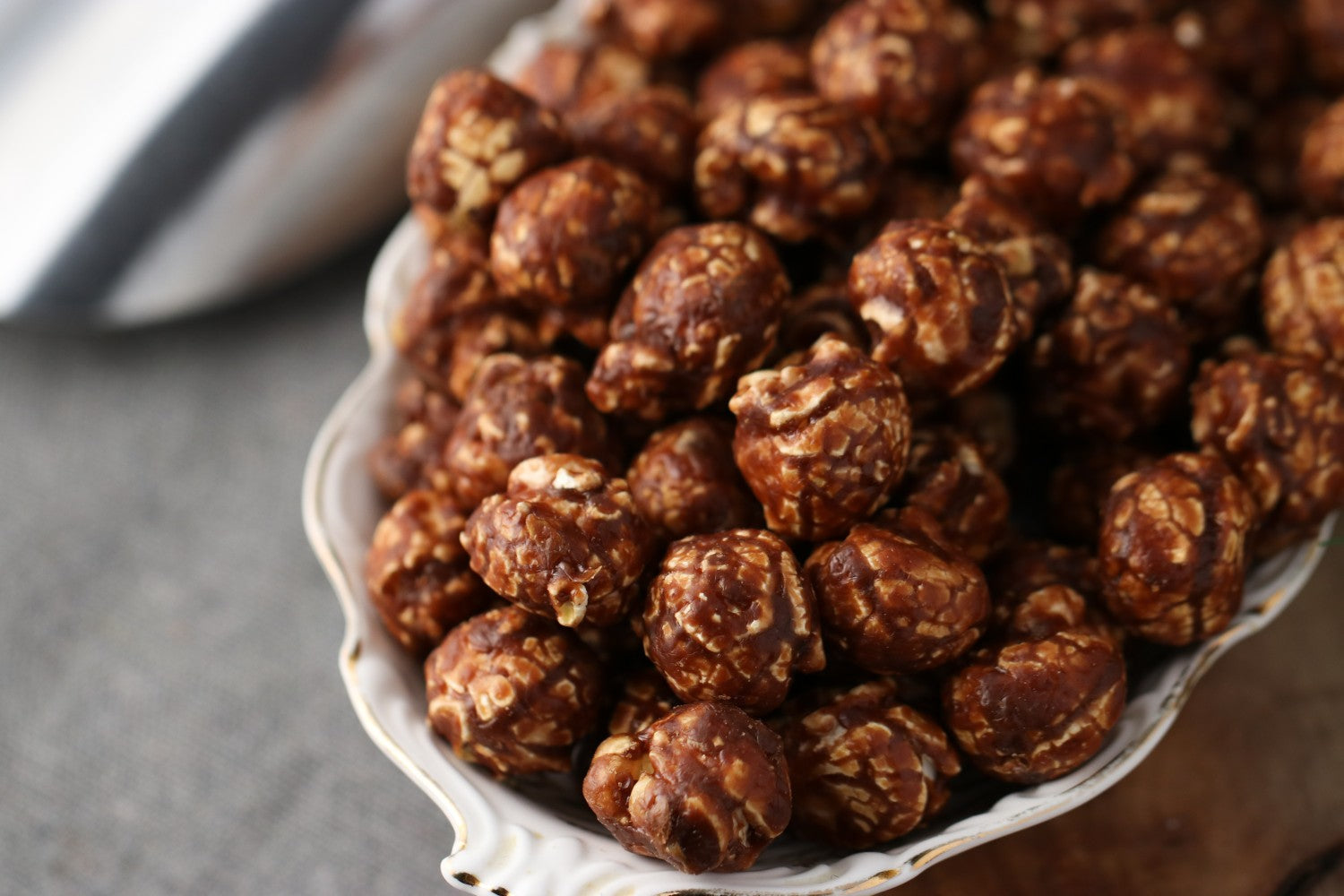 Close up view of Bowl of chocolate peanut candied popcorn on a wooden surface from Toronto Popcorn company