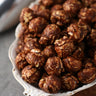 Close up view of Bowl of chocolate peanut candied popcorn on a wooden surface from Toronto Popcorn company