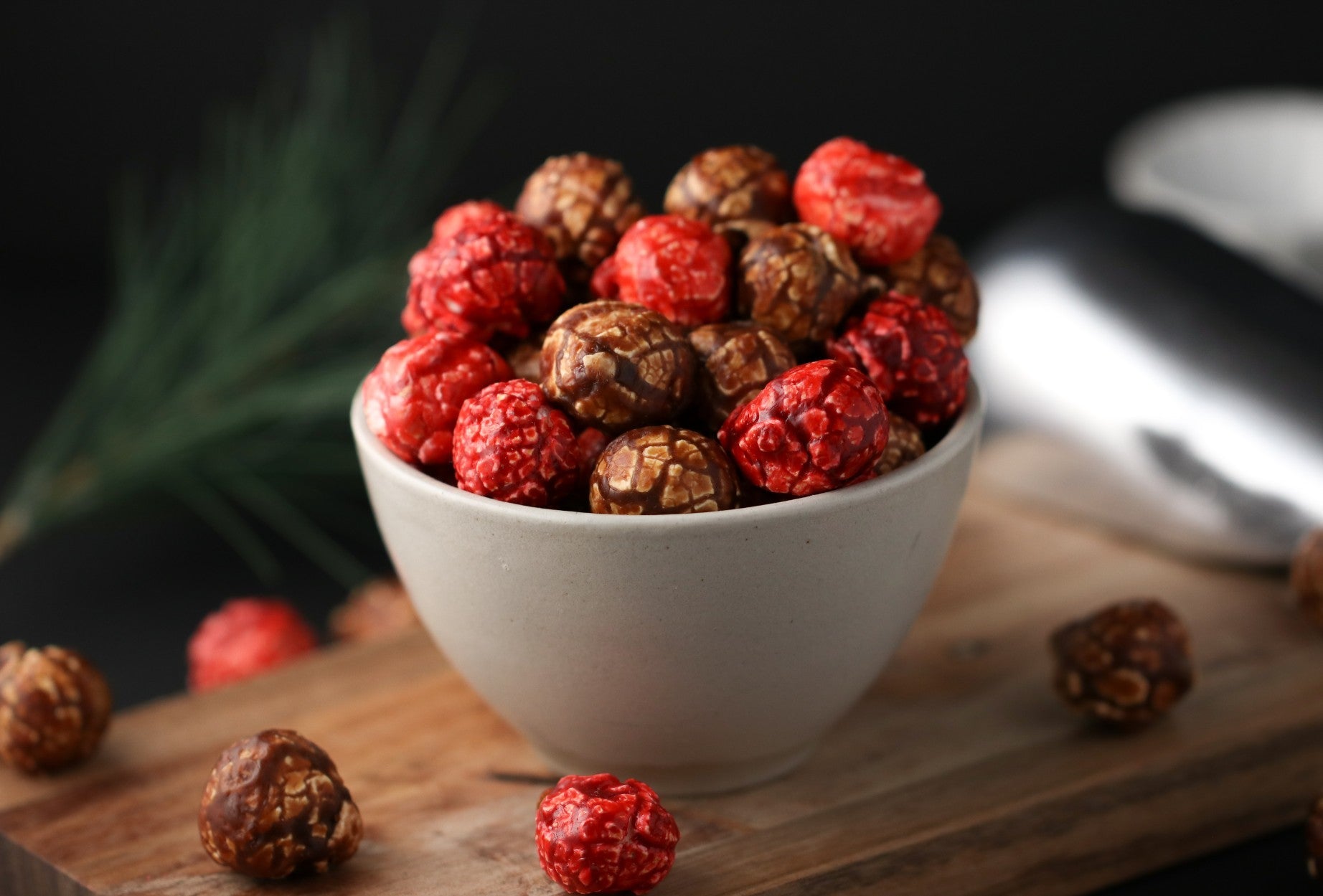 White bowl filled with red and brown candied popcorn from the Toronto Popcorn company