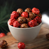 White bowl filled with red and brown candied popcorn from the Toronto Popcorn company