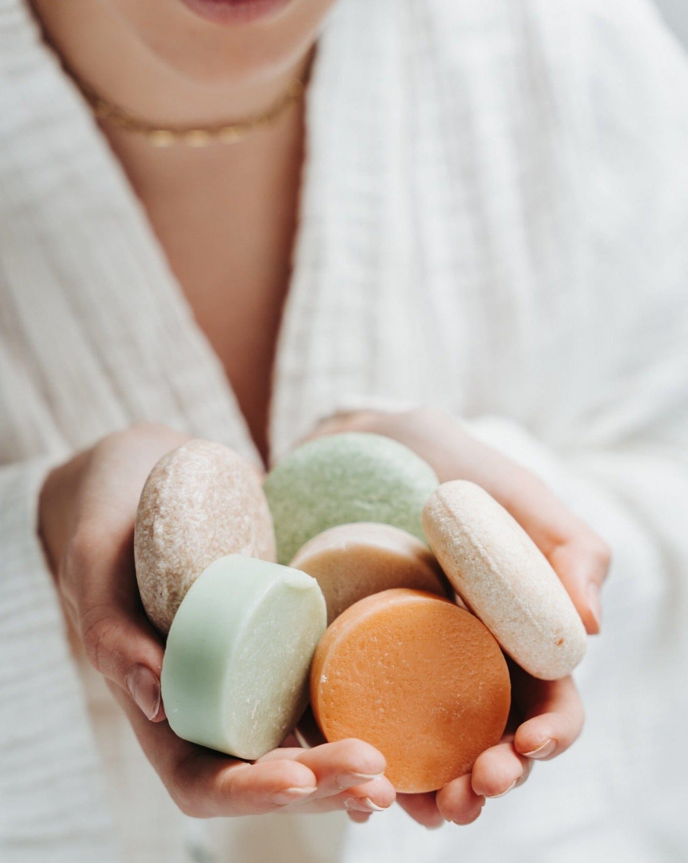 Person holding colorful bath bombs in their hands