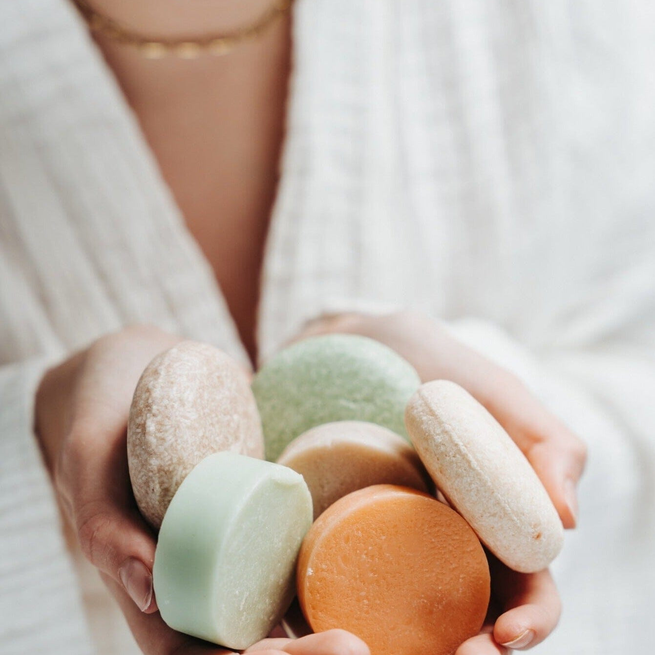 Person holding colorful macaron cookies in their hands