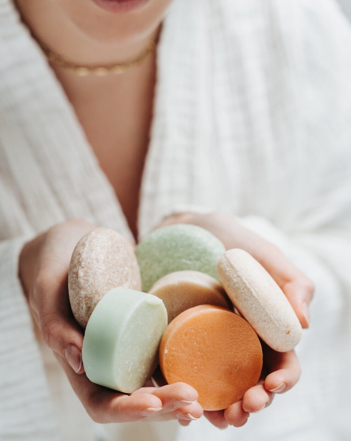 Person holding colorful macaron cookies in their hands