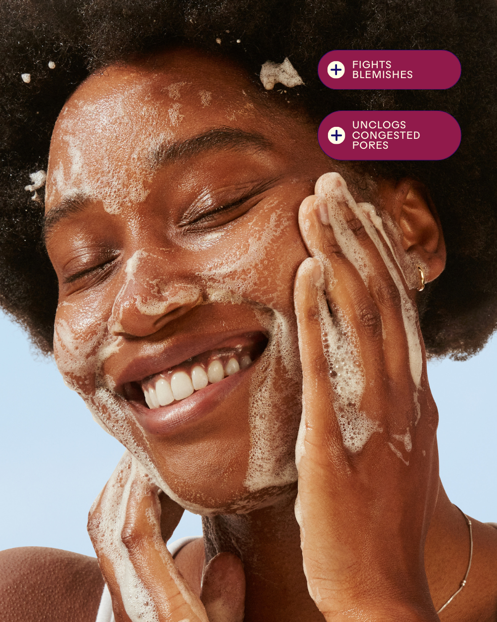 Woman enjoying a foaming cleanser, highlighting benefits of fighting blemishes and unclogging pores.