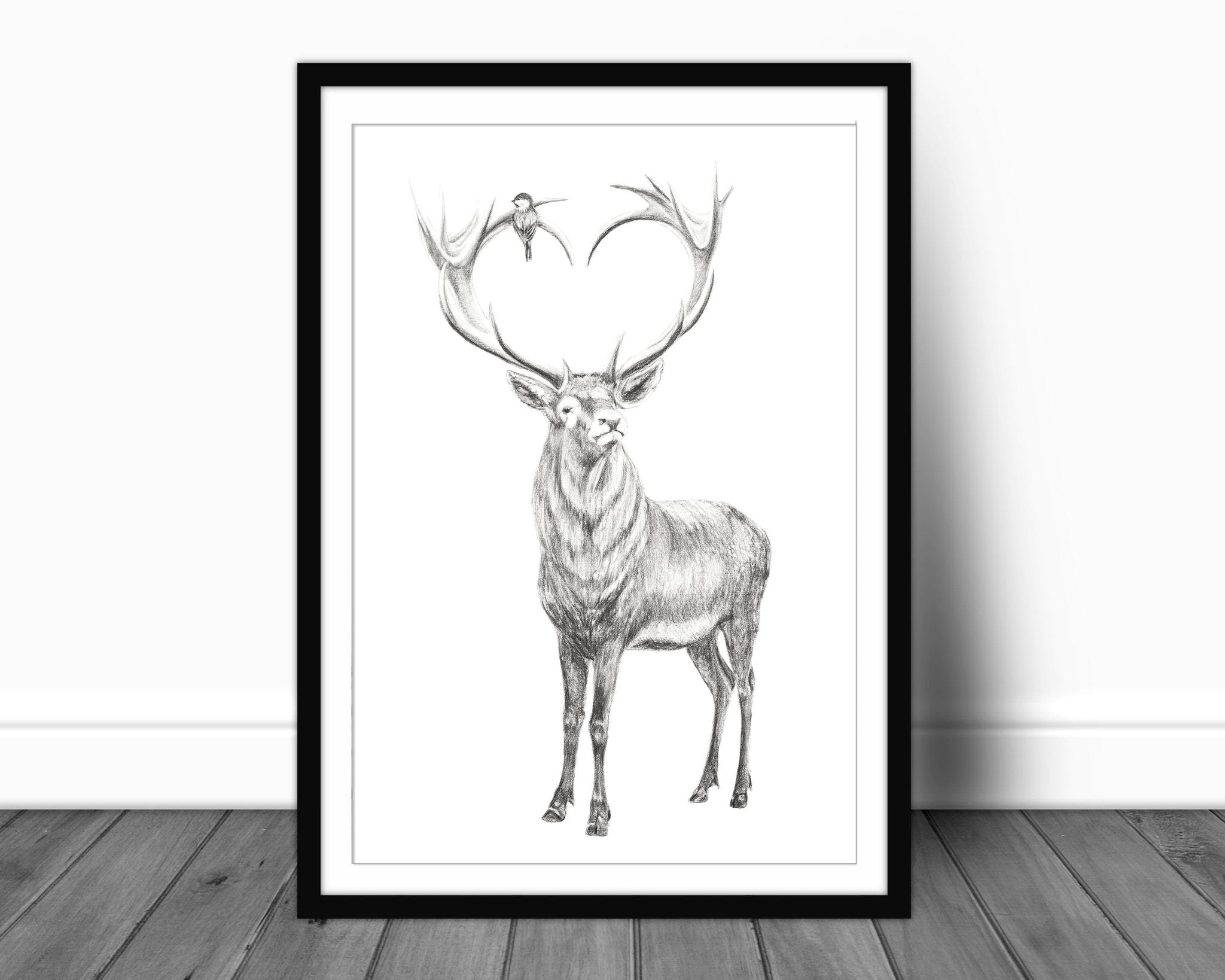 Framed black and white illustration of a deer on a wooden floor.