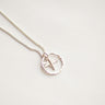 Silver necklace with a dragonfly pendant on a light gray background