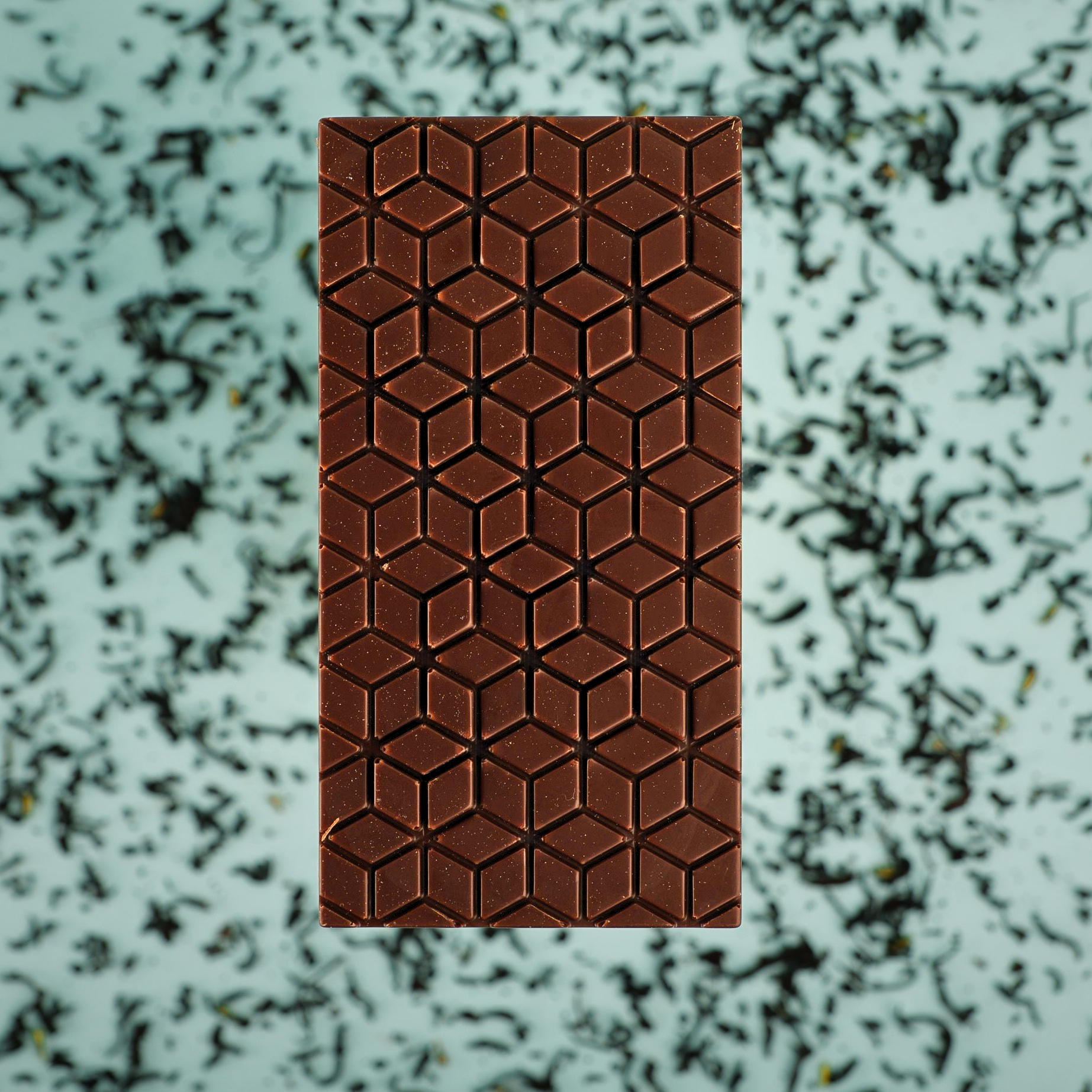 earl grey lavander chocolate bar with geometric pattern on a textured green background
