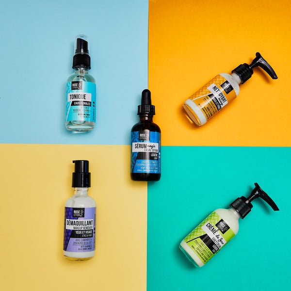 Four skincare bottles on a colorful geometric background
