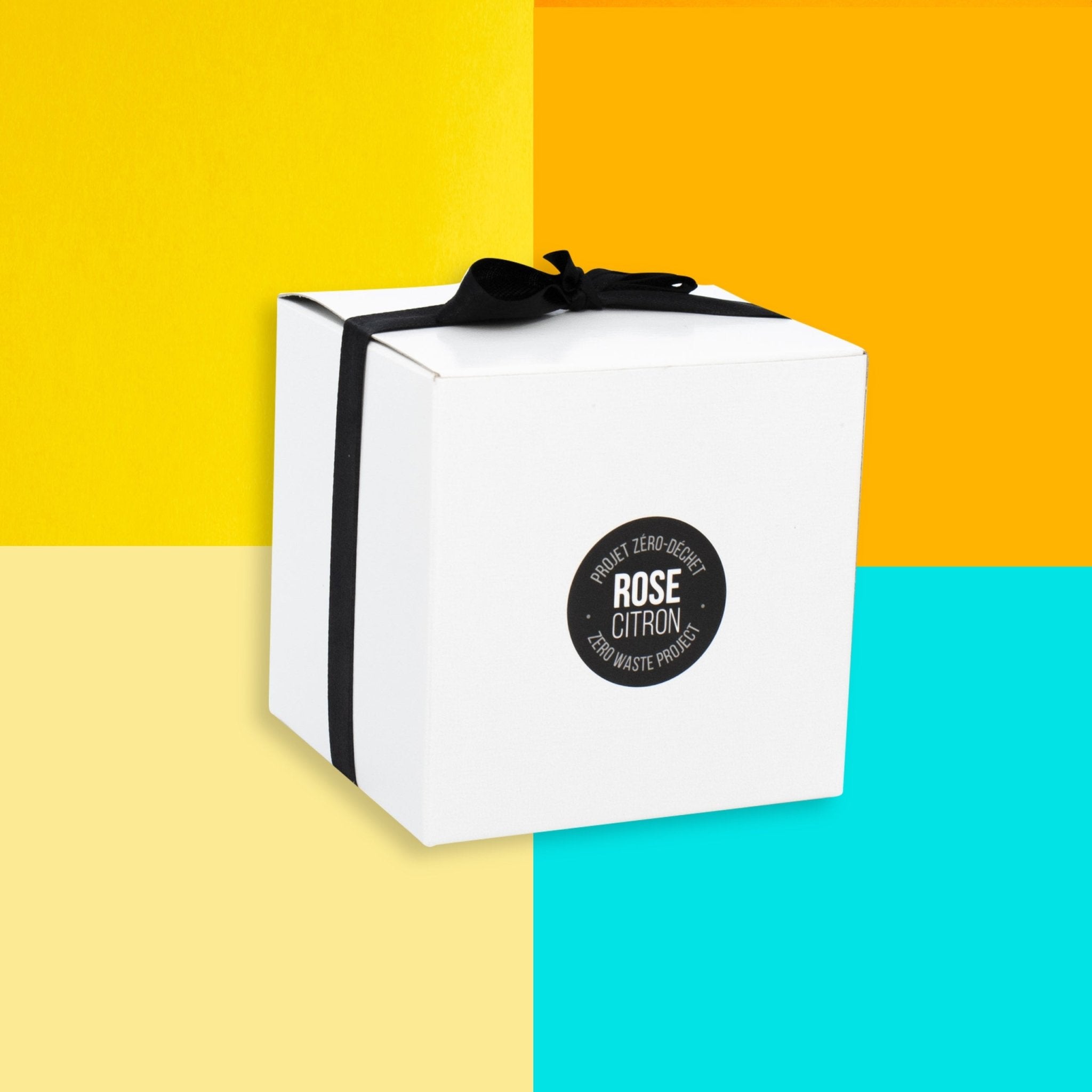 White gift box with a black ribbon on a multicolored background