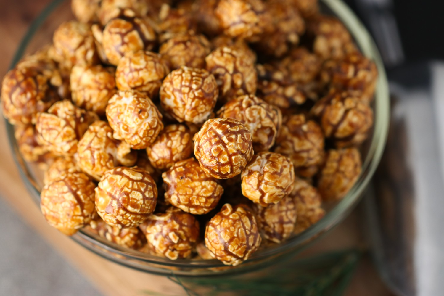 Bowl of espresso caramel candied popcorn on a wooden surface from Toronto Popcorn company