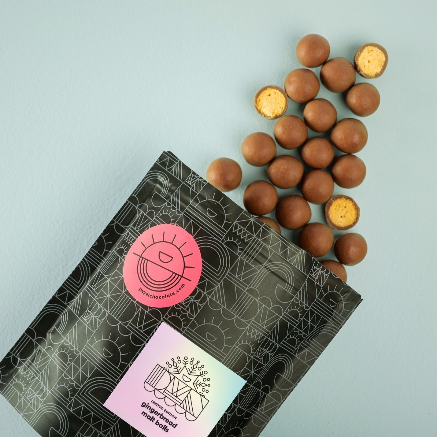 Gingerbread balls with a branded packaging on a light blue background