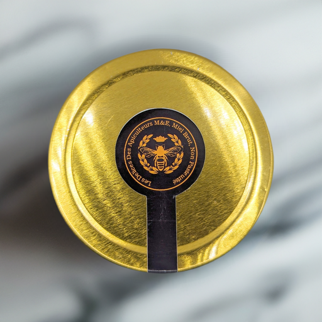 Gold lid with a black label featuring a bee emblem on a gray background