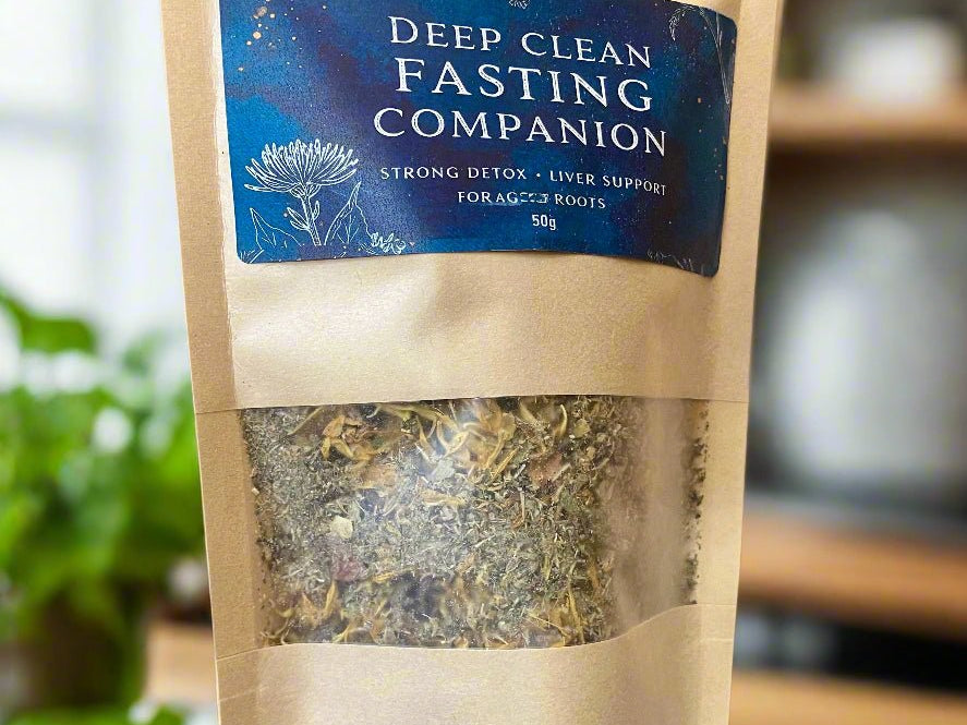 Kraft paper packaging of 'Deep Clean Fasting Companion' on a wooden surface with a blurred background. Kootenay Woman