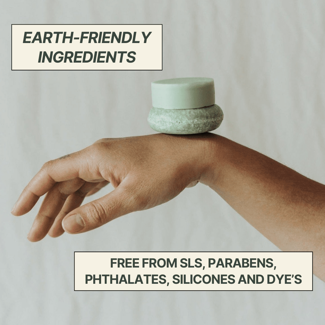 Hand holding a small container with text about earth-friendly ingredients and chemical free products.