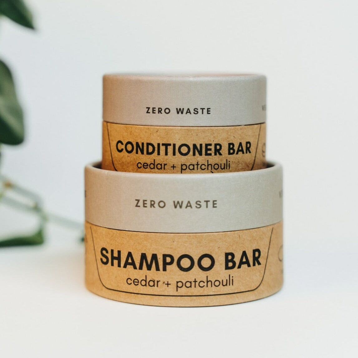 Two zero waste shampoo and conditioner bars with natural packaging on a white background.