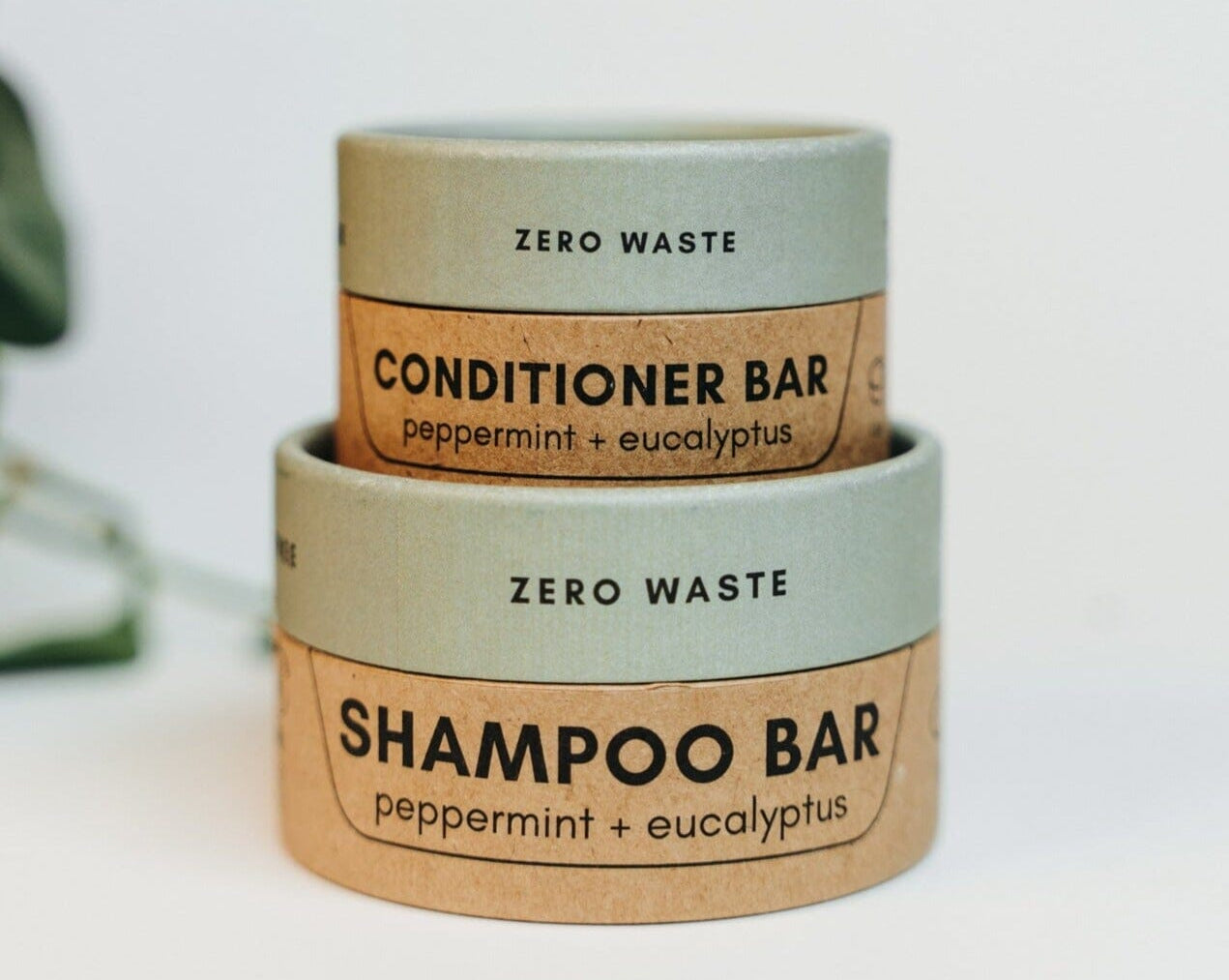 Two zero waste shampoo and conditioner bars with labels on a white background