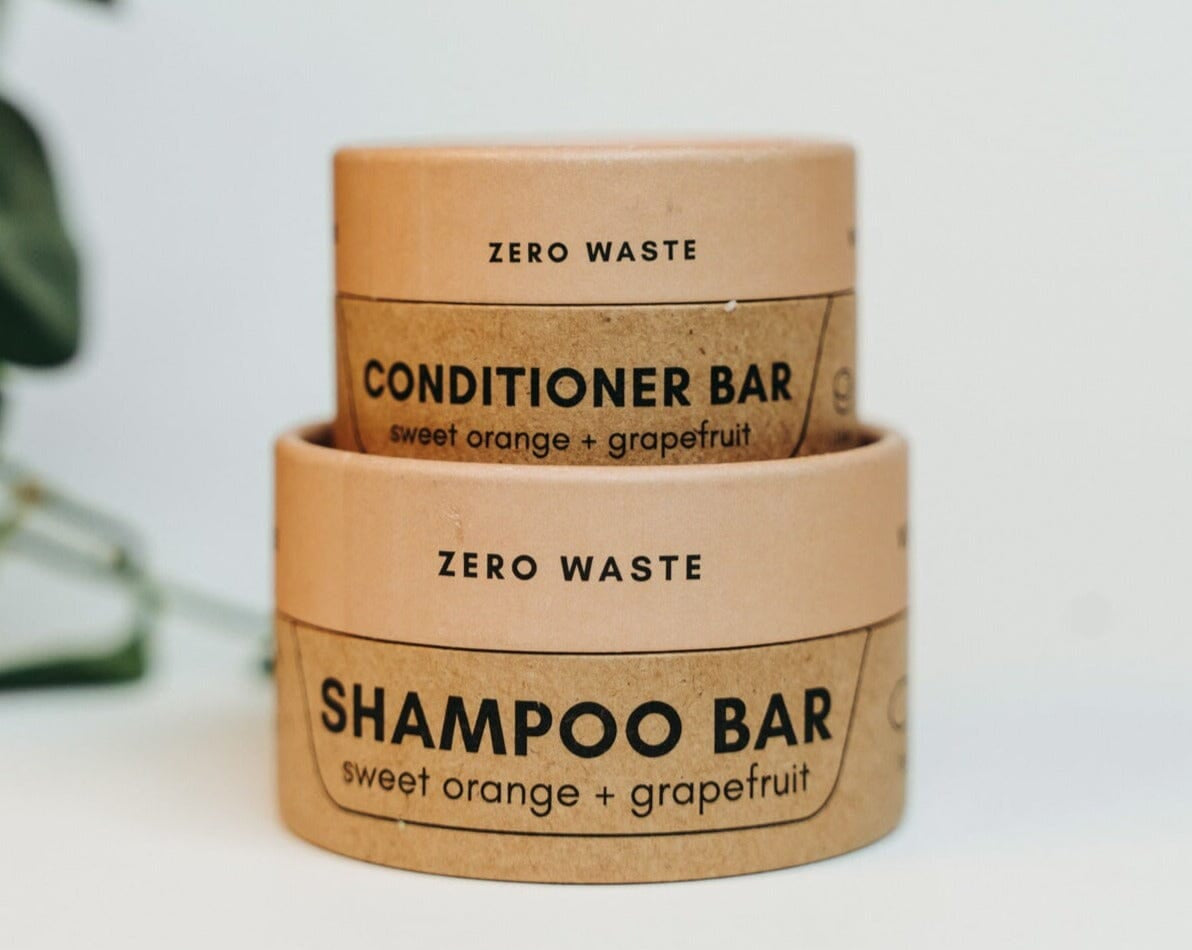 Two zero waste shampoo and conditioner bars with labels on a light background