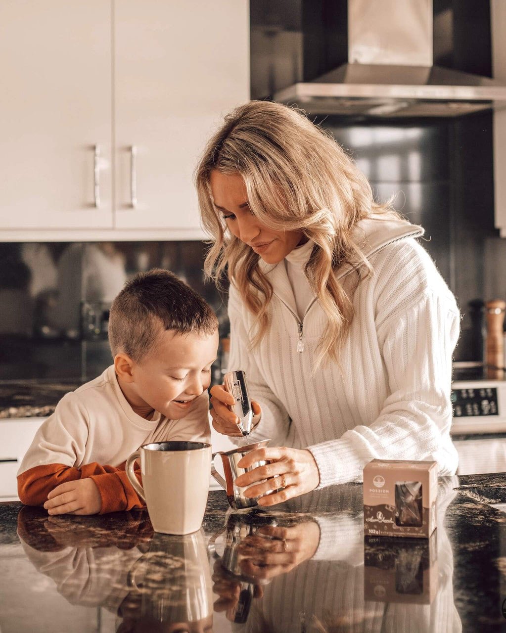 Woman and child in a kitchen preparing a drink together.