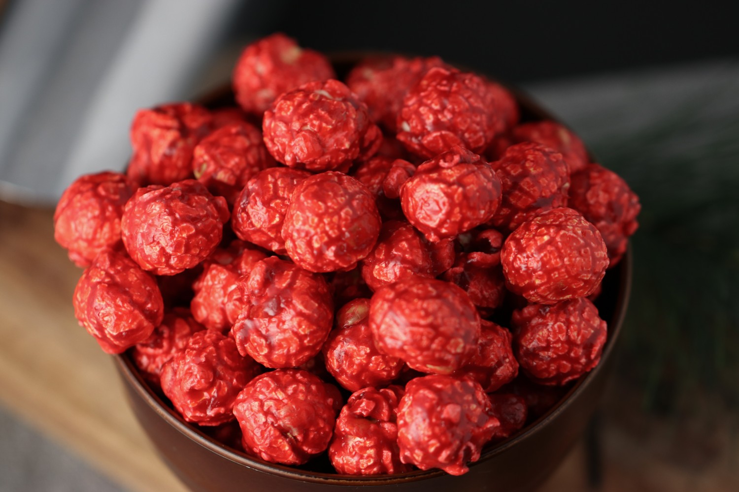 close view of a Bowl of hot cinnamon candied popcorn on a wooden surface from Toronto Popcorn company
