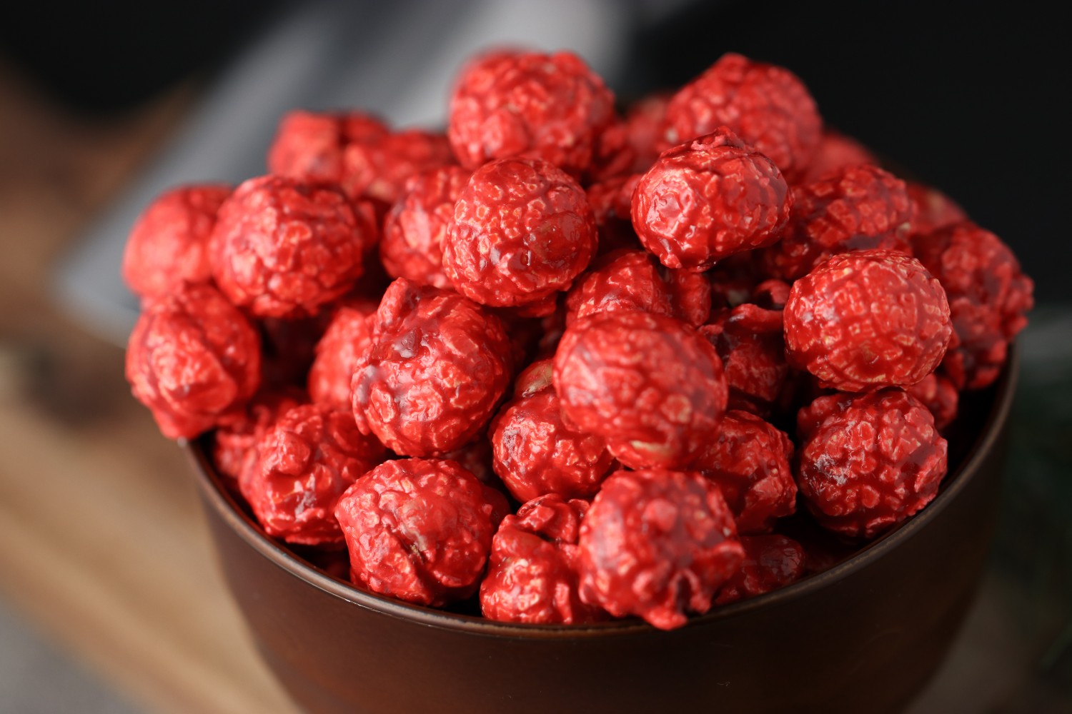 Bowl of hot cinnamon candied popcorn on a wooden surface from Toronto Popcorn company